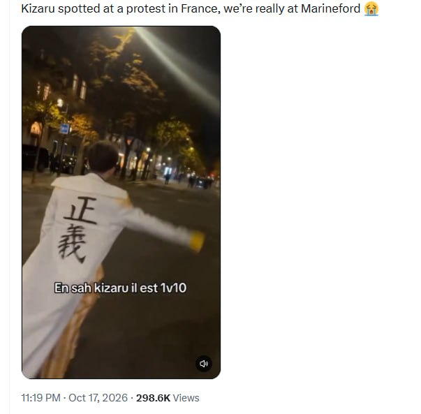 Cosplay of an anime character in a white coat walking down a street at night during protests